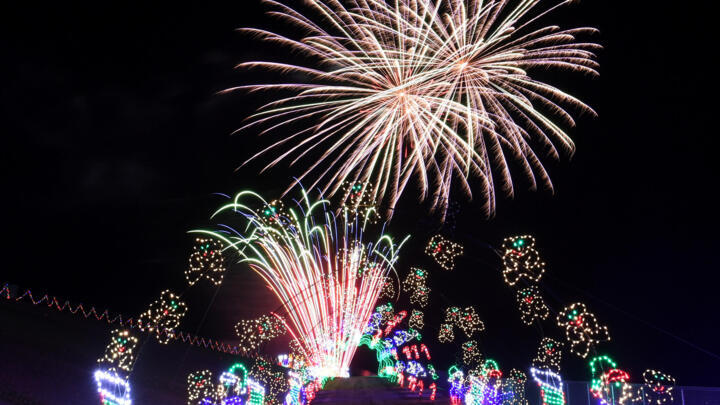 Fireworks explode behind a tunnel of lights as the Glittering Lights drive-thru light show opens at the Las Vegas Motor Speedway on November 13, 2020, in Las Vegas, Nevada.