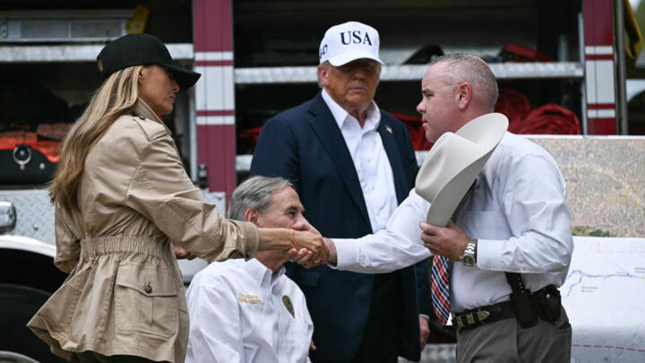 US President Donald Trump, Texas Governor Greg Abbott (2L), and First Lady Melania Trump (L) meet local officials near the Guadalupe River in Texas on July 11, 2025.