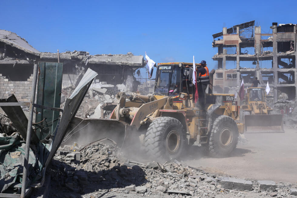 Des bulldozers de la municipalité de Gaza déblayent les décombres des bâtiments sur les axes principaux et les rues de la ville de Gaza, le 14 octobre 2025