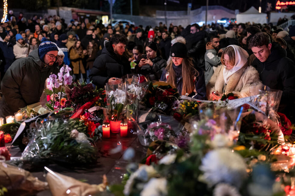Des personnes rendent hommage aux victimes de l'incendie qui s'est déclaré dans un bar à Crans-Montana, en Suisse, pendant les festivités du Nouvel An, le 1er janvier 2026.