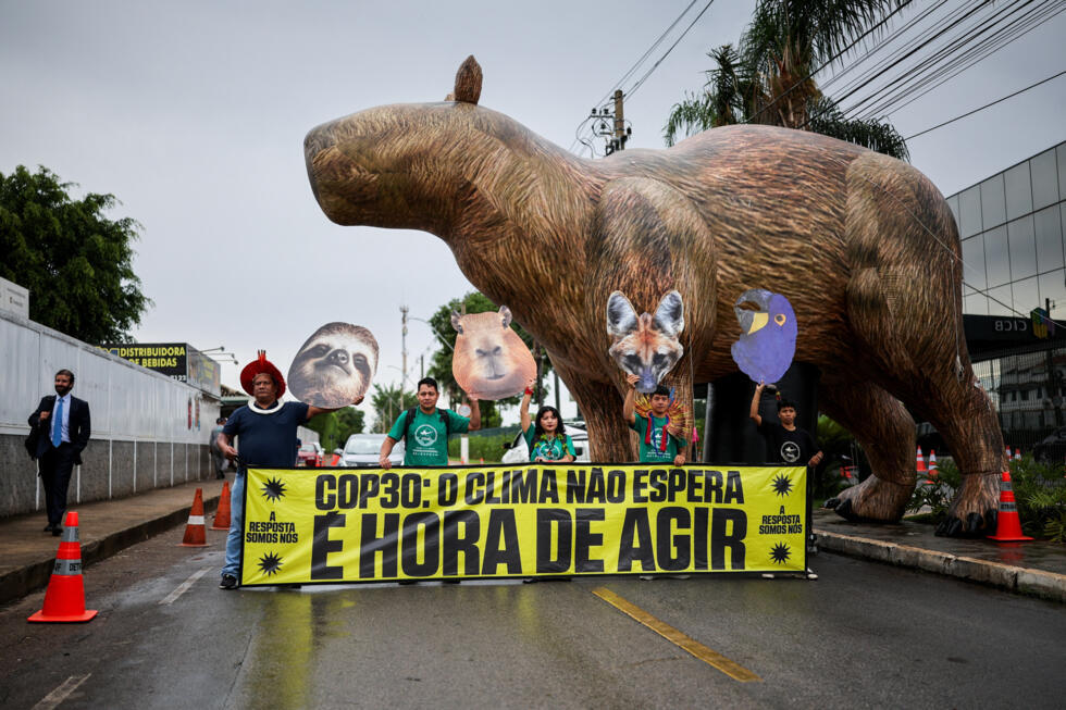 Activistas de la Coordinadora de las Organizaciones Indígenas de la Amazonía Brasileña (COIAB) junto a un carpincho inflable gigante, mientras realizan una protesta para exigir a los negociadores de la COP30 que protejan los bosques amazónicos, mientras se lleva a cabo la reunión preparatoria ministerial (Pre-COP30), antes de la Cumbre del Clima COP30, en Brasilia, Brasil, el 14 de octubre de 2025.
