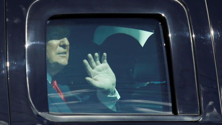 Donald Trump waves from a car as he drives past supporters in West Palm Beach, Florida, on January 20, snubbing his successor's inauguration.