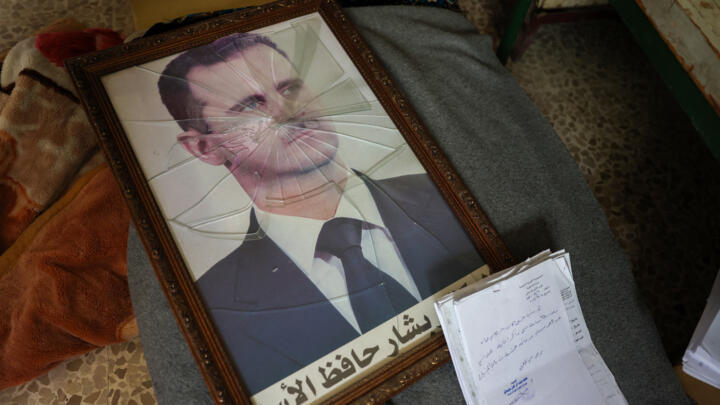 A portrait of Syrian President Bashar al-Assad is pictured with its frame broken, in a Syrian regime's Political Security Branch facility on the outskirts of the central city of Hama, following the ca