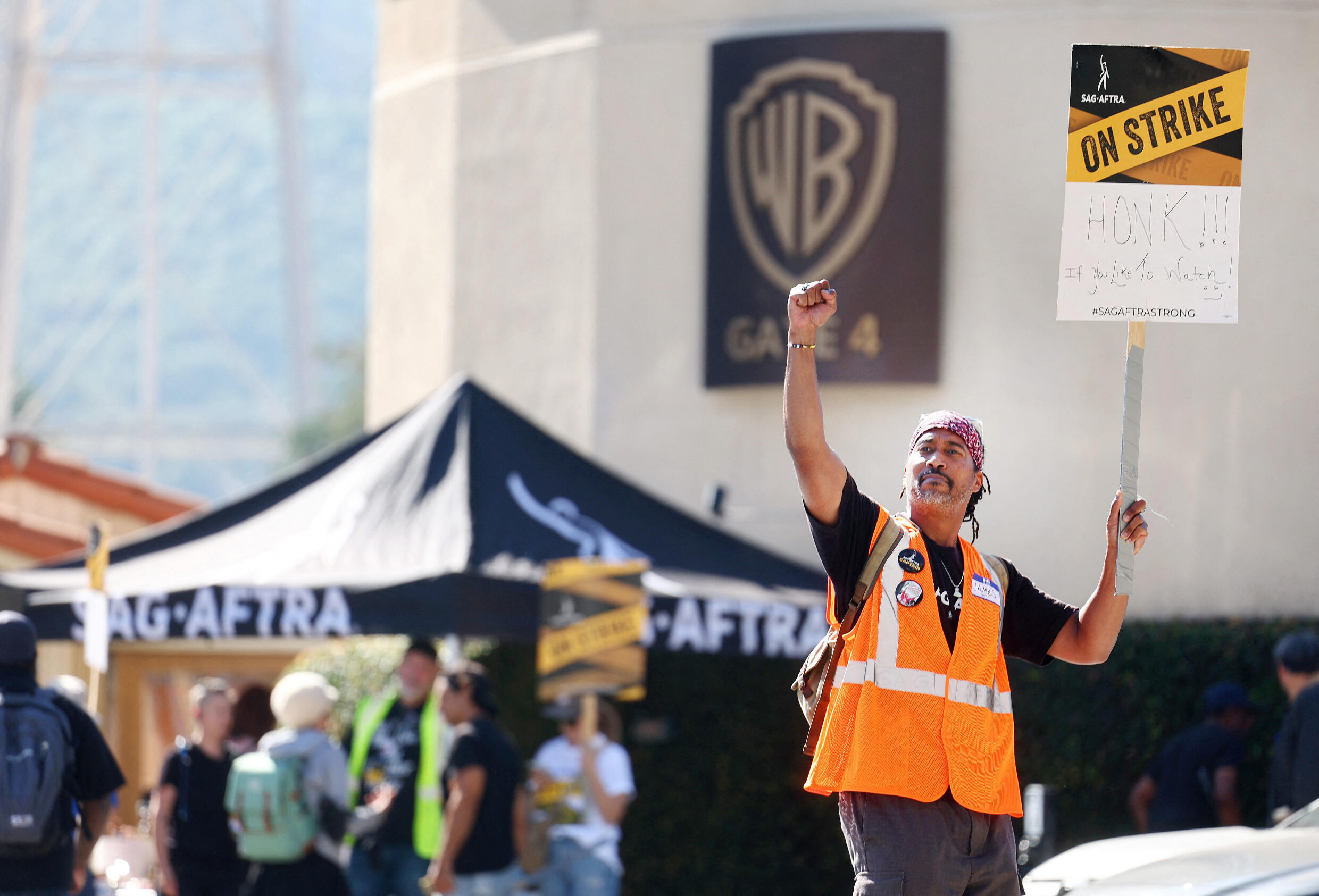 Un membre du SAG-AFTRA, un syndicat professionnel américain représentant plus de 160 000 acteurs, figurants, et professionnels des médias, défile devant les studios Warner Bros à Burbank en Californie, le 26 septembre 2023.