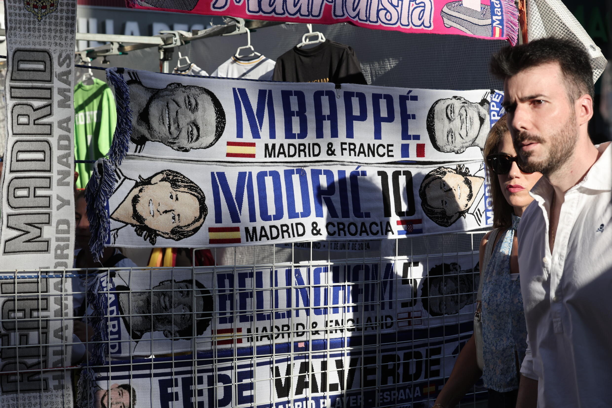 Des écharpes au nom du footballeur français Kylian Mbappé, du joueur croate Luka Modric et du Britannique Jude Bellingan sont exposées sur un stand de vendeurs ambulants à l'extérieur du stade Santiago Bernabeu à Madrid le 1er juin 2024
