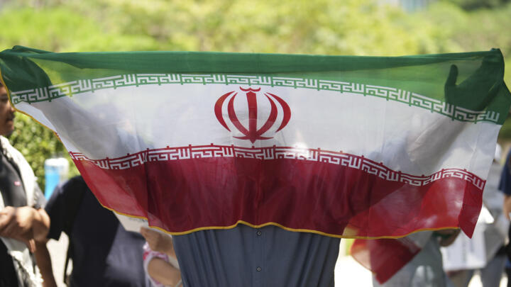 File photo of a man holding an Iranian flag taken at a rally in Seoul, South Korea, on June 22, 2025.
