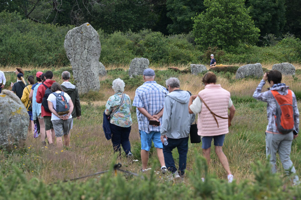 Des visiteurs sur le site des Mégalithes de Carnac, le 27 juin 2025 dans le Morbihan en France.