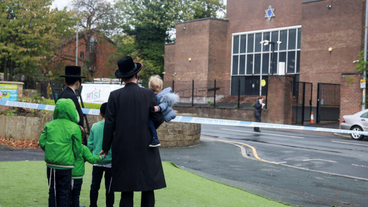 People stand by the cordon outside the Manchester synagogue, where multiple people were killed on Yom Kippur in what police have declared a terrorist incident, in north Manchester, UK, October 5, 2025.