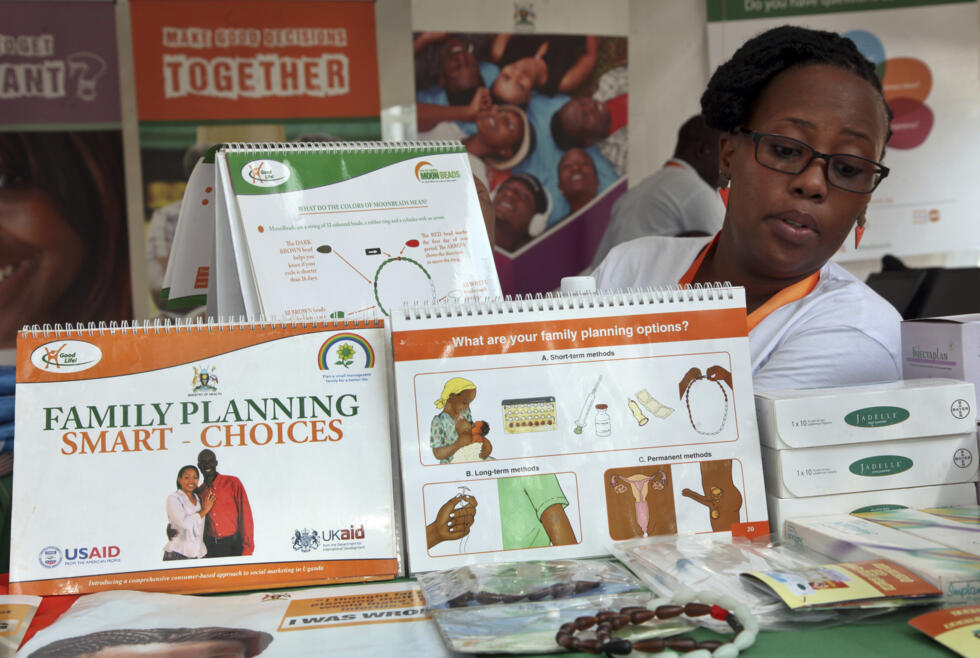 En esta foto tomada el martes 26 de septiembre de 2017, la trabajadora sanitaria Sylvia Marettah Katende muestra productos e información sobre salud reproductiva en una exposición sobre planificación familiar en Kampala, Uganda.