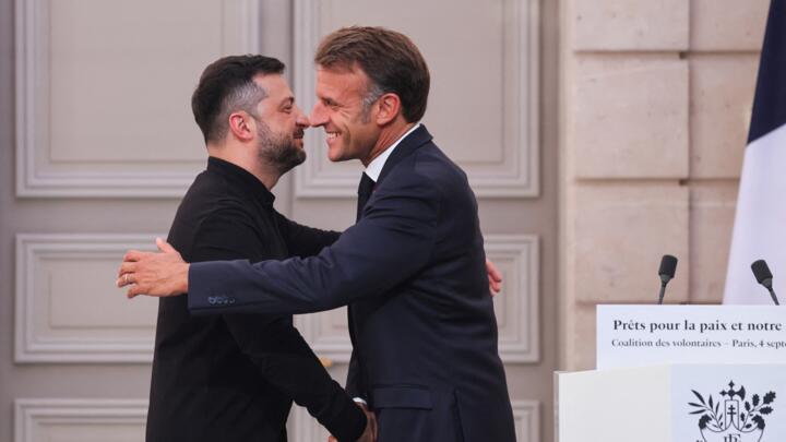 Ukraine's President Volodymyr Zelensky (L) shakes hands with France's President Emmanuel Macron during a press conference following the Coalition of the Willing Summit at the Elysee presidential Palac