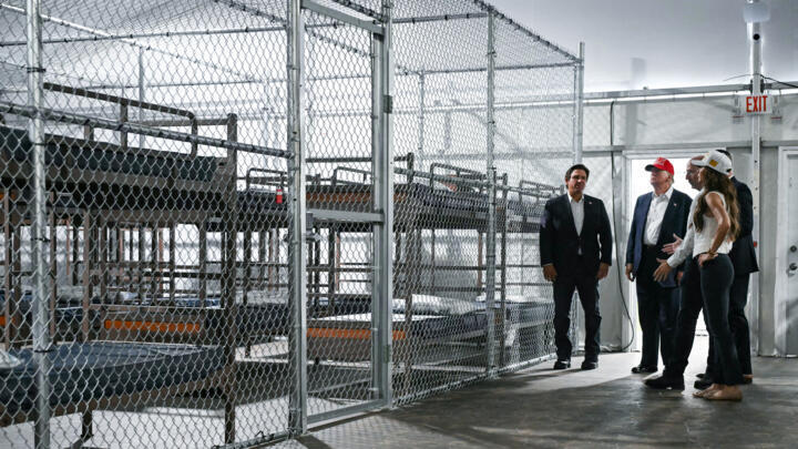 US President President Donald Trump (2L), Florida Governor Ron DeSantis (L), and Secretary of Homeland Security Kristi Noem (R) tour the migrant detention centrer, dubbed "Alligator Alcatraz" in Florida on July 1, 2025.