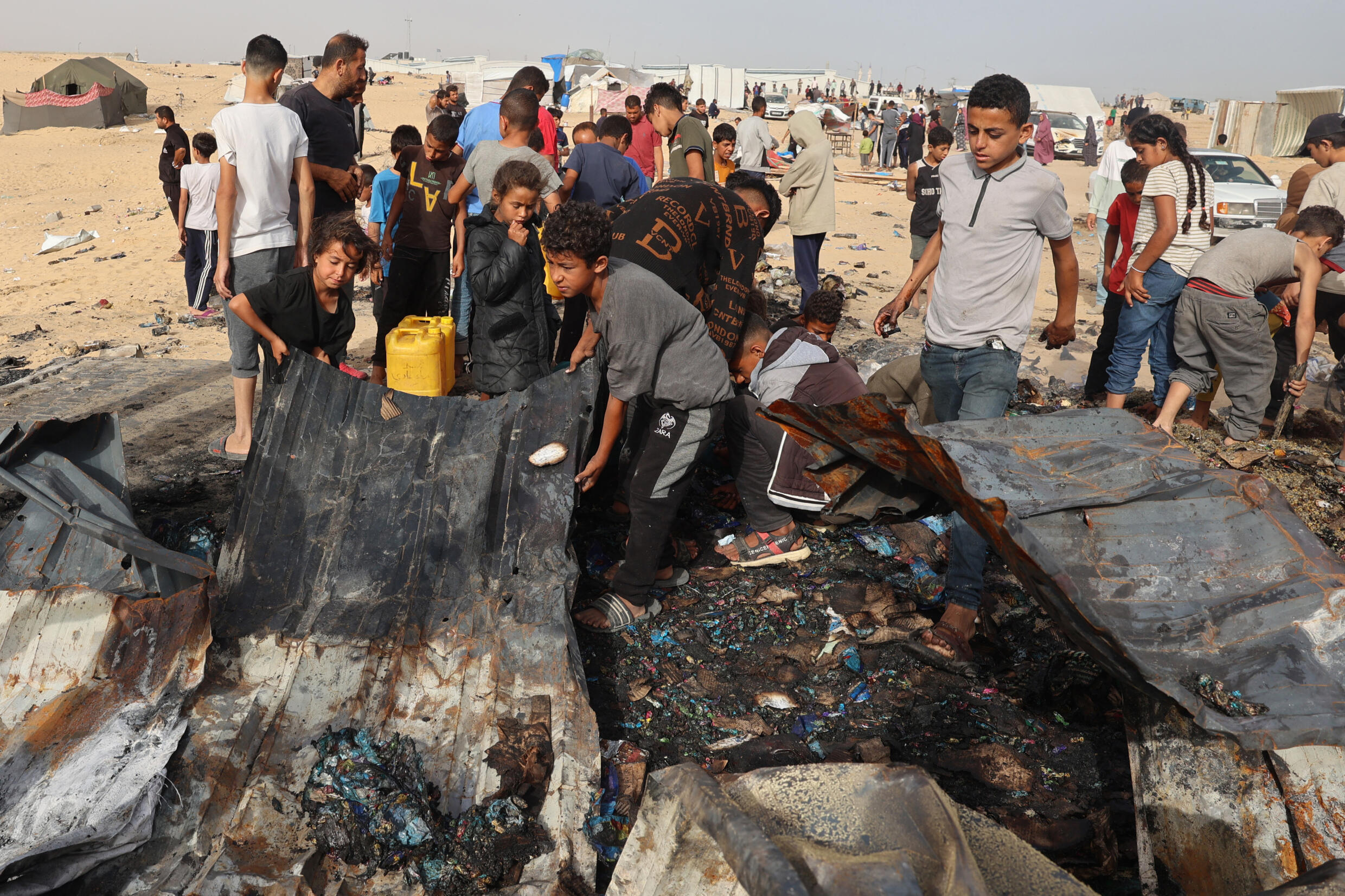 Des Palestiniens rassemblé sur le site d'une attaque israélienne contre un camp de personnes déplacées à Rafah, le 27 mai 2024
