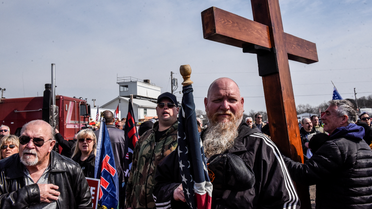 La gente escucha una canción patriótica después de que algunos de ellos llegaran como parte del convoy que recorrió el país en dirección a Washington D.C. en Hagerstown, Maryland, Estados Unidos, el 5 de marzo de 2022.