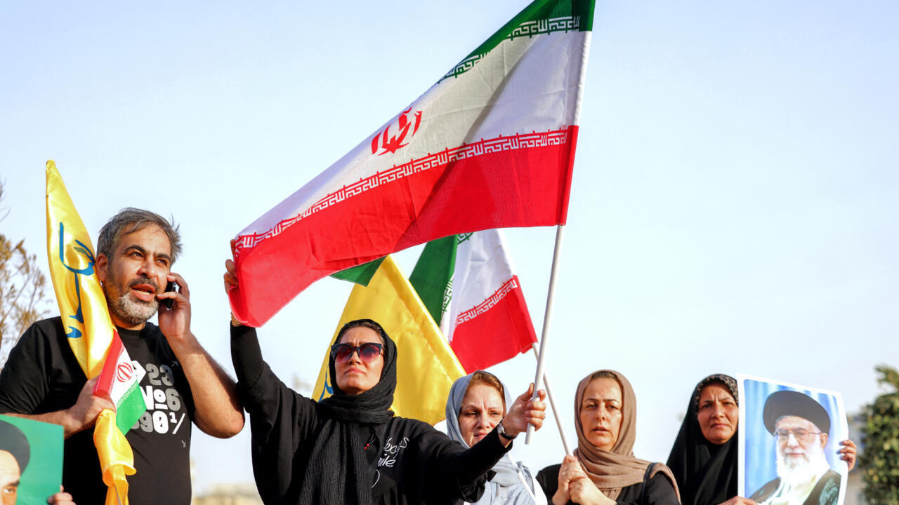 Iranians wave national flags as they celebrate a ceasefire between Iran and Israel in Tehran on June 24, 2025.