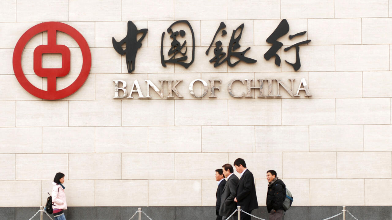 Esta foto tomada el 14 de diciembre de 2009 muestra a peatones caminando frente al Banco de China en Pekín. Los nuevos préstamos bancarios chinos aumentaron en noviembre tras caer al nivel más bajo del año el mes anterior, según informó el banco central el 11 de diciembre, ya que las entidades crediticias siguieron apoyando los masivos esfuerzos de estímulo económico.