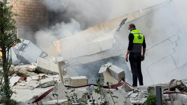 A civil defence member stands on rubble at a damaged site after Israel's military said it struck targets in two southern Lebanese towns on Thursday, in Jbaa southern Lebanon, December 4, 2025.