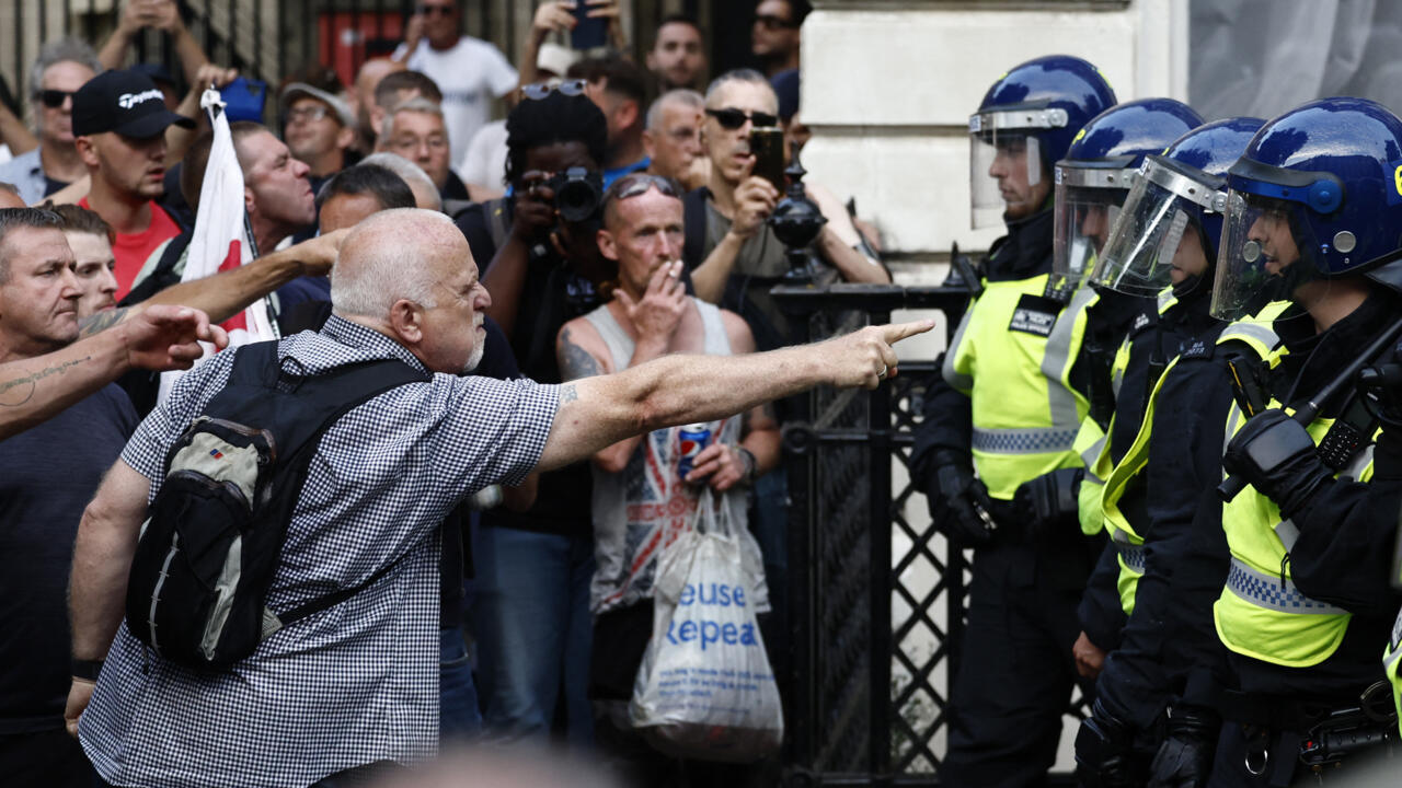 Protestors remonstrate with Police officers during the 'Enough is Enough' demonstration on Whitehall, outside the entrance to 10 Downing Street in central London on July 31, 2024.