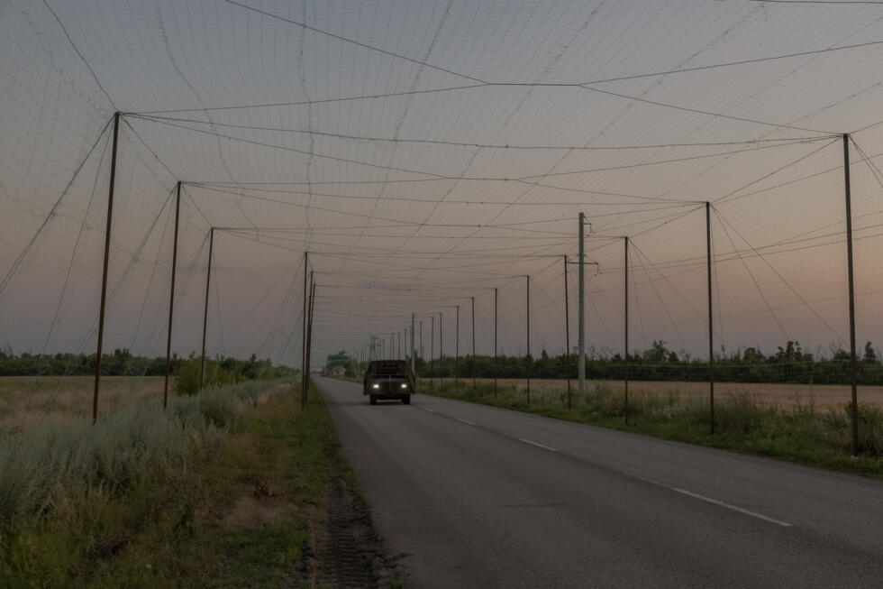 The tunnels of green nets span long stretches of road