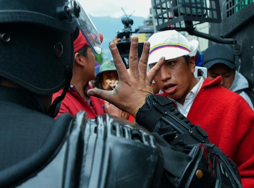 Un oficial de policía hace un gesto mientras habla a los indígenas reunidos en el área del parque El Arbolito en Quito, el 22 de junio de 2022, en el décimo día consecutivo de protestas lideradas por indígenas contra el gobierno ecuatoriano.