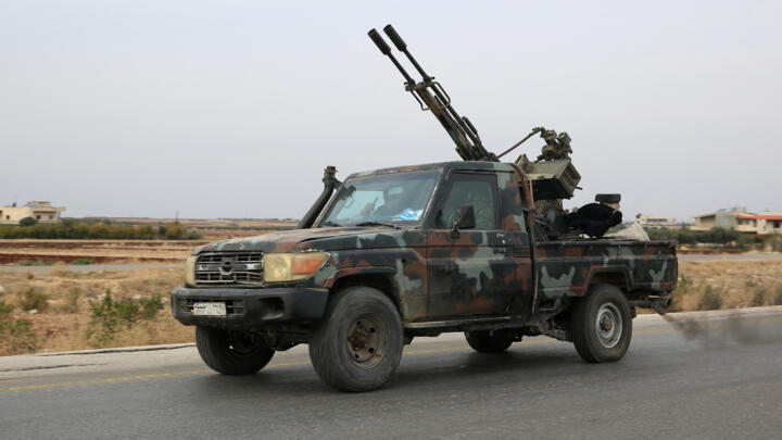 Anti-government forces drive in the city of al-Rastan in Syria's Homs province on December 7, 2024.