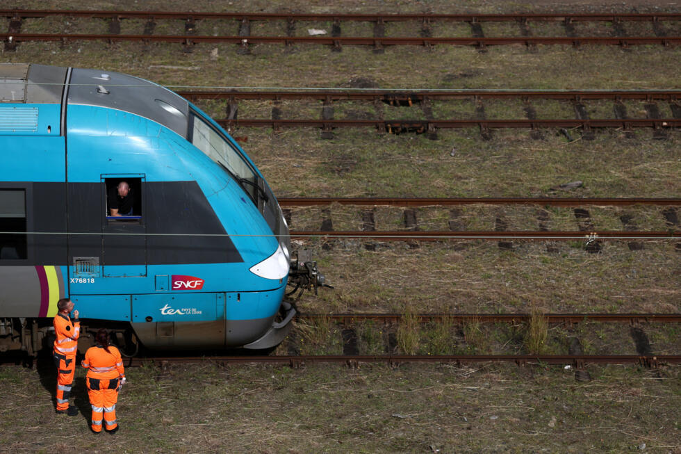 Workers stand next to a SNCF regional train at the railway station in Nantes two days before a strike by French state-owned railway SNCF workers, in France, on September 16, 2025.