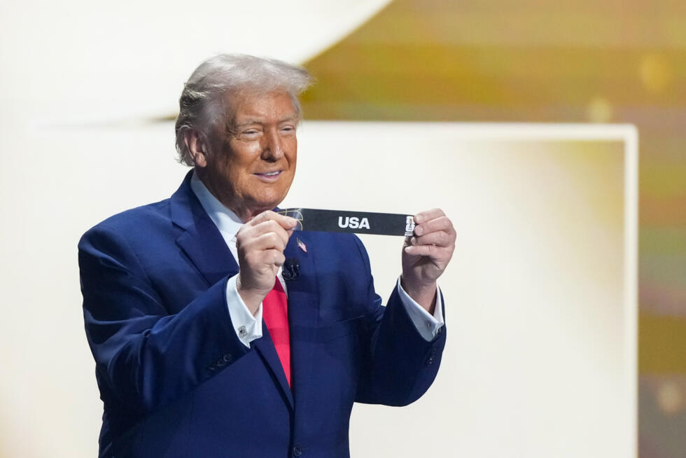 Le président américain, Donald Trump, montre un papier avec le nom des Etats-Unis lors du tirage au sort de la Coupe monde 2026 de football, le 5 décembre 2025 au Kennedy Center à Washington