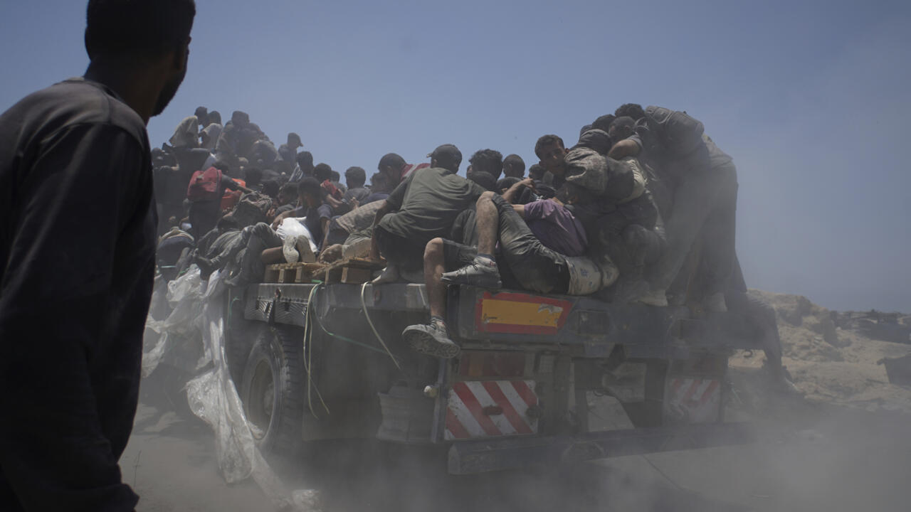 ARCHIVO - Palestinos se agarran a un camión de ayuda que regresa a la ciudad de Gaza desde el norte de la Franja de Gaza el martes 22 de julio de 2025.