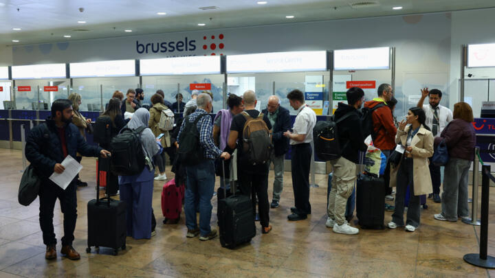 Passengers wait in line at a service desk at Brussels Airport after the Belgian air traffic control service reported a sighting of a drone, in Zaventem, Belgium, November 4, 2025.