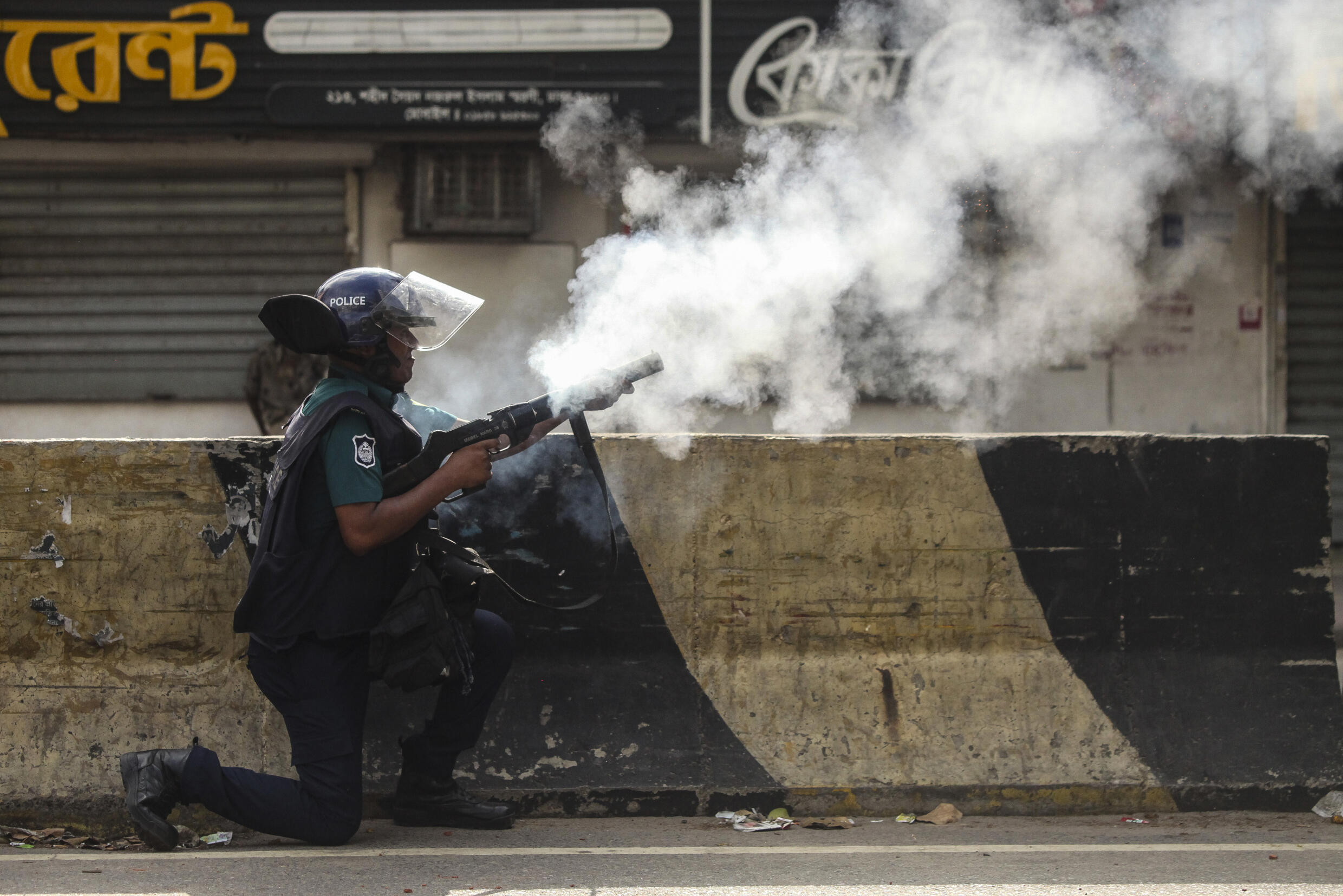 Un policier tire des gaz lacrymogènes sur des manifestants opposés aux quotas dans la fonction publique, le 19 juillet 2024 à Dacca, au Bangladesh
