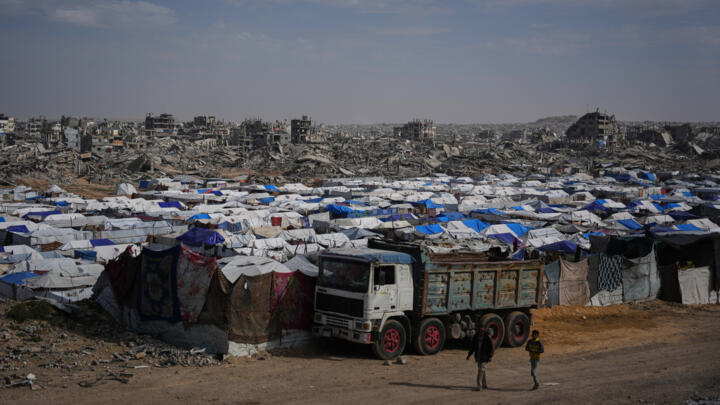 Tents sheltering displaced Palestinians stand amid the destruction left by the Israeli air and ground offensive in Gaza City on December 5, 2025.
