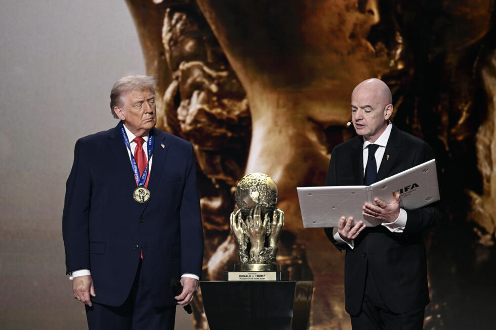 Le président américain Donald Trump (g) reçoit le prix de la paix de la FIFA des mains du président de la FIFA, Gianni Infantino, lors du tirage au sort de la Coupe du monde de football de la FIFA 2026, au Kennedy Center, à Washington, le 5 décembre 2025