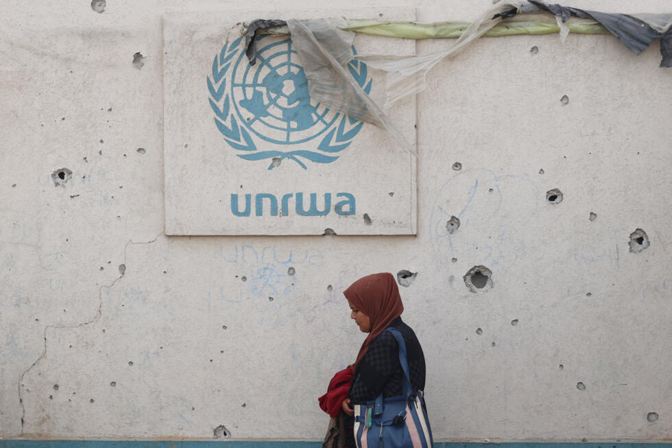 Le logo de l'Unrwa sur un mur criblé d'impacts dans un camp pour personnes déplacées à Rafah, dans le sud de la bande de GAza, le 28 mai 2024
