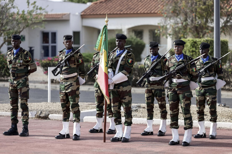 A Senegalese soldier holds a Senegal flag during a ceremony where France will return Camp Geille, its largest base in the country, and its airfield at Dakar airport, in Dakar on July 17, 2025.