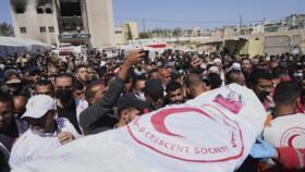 Mourners carry the bodies of 8 Red Crescent emergency responders, recovered in Rafah a week after an Israeli attack, as they are transported for burial from a hospital in Deir al-Balah, Gaza Strip, on