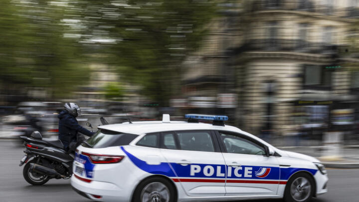 A French police officer drives a police car next to a scooter on a street in Paris in this file photo taken on April 16, 2025.