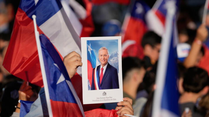 Supporters hold a portrait of Jose Antonio Kast, presidential candidate of the opposition Republican Party, on Sunday Dec. 14, 2025 in Santiago, Chile.