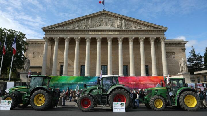 Farmers stand next to tractors during a rally organised by the FNSEA and Jeunes Agriculteurs (JA) unions outside the French National Assembly in Paris, on May 26, 2025