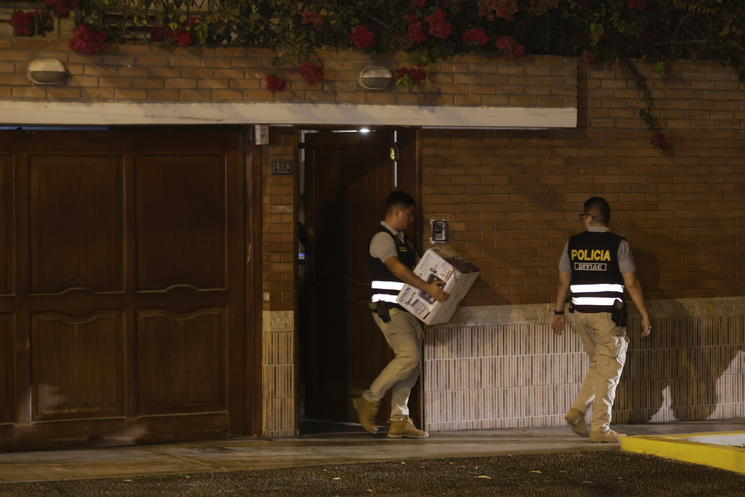 Des policiers quittent le domicile de la présidente péruvienne Dina Boluarte lors d'une perquisition ordonnée par le ministère public dans le cadre d'une enquête préliminaire, le 30 mars 2024 à Lima
