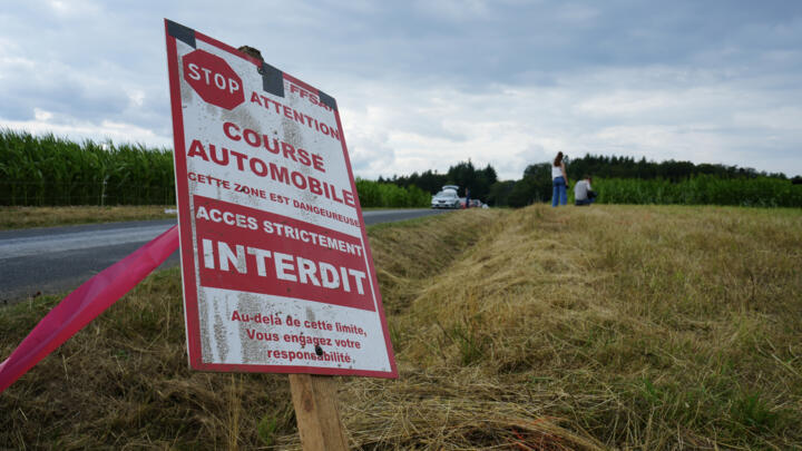 A sign prohibiting access is seen near the scene where three spectators were killed when a car veered off course during an auto rally in central France