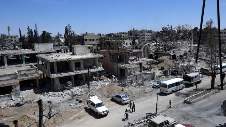 Syrians walk through destruction in the town of Douma, the site of a suspected chemical weapons attack, near Damascus, Syria on April 16, 2018.