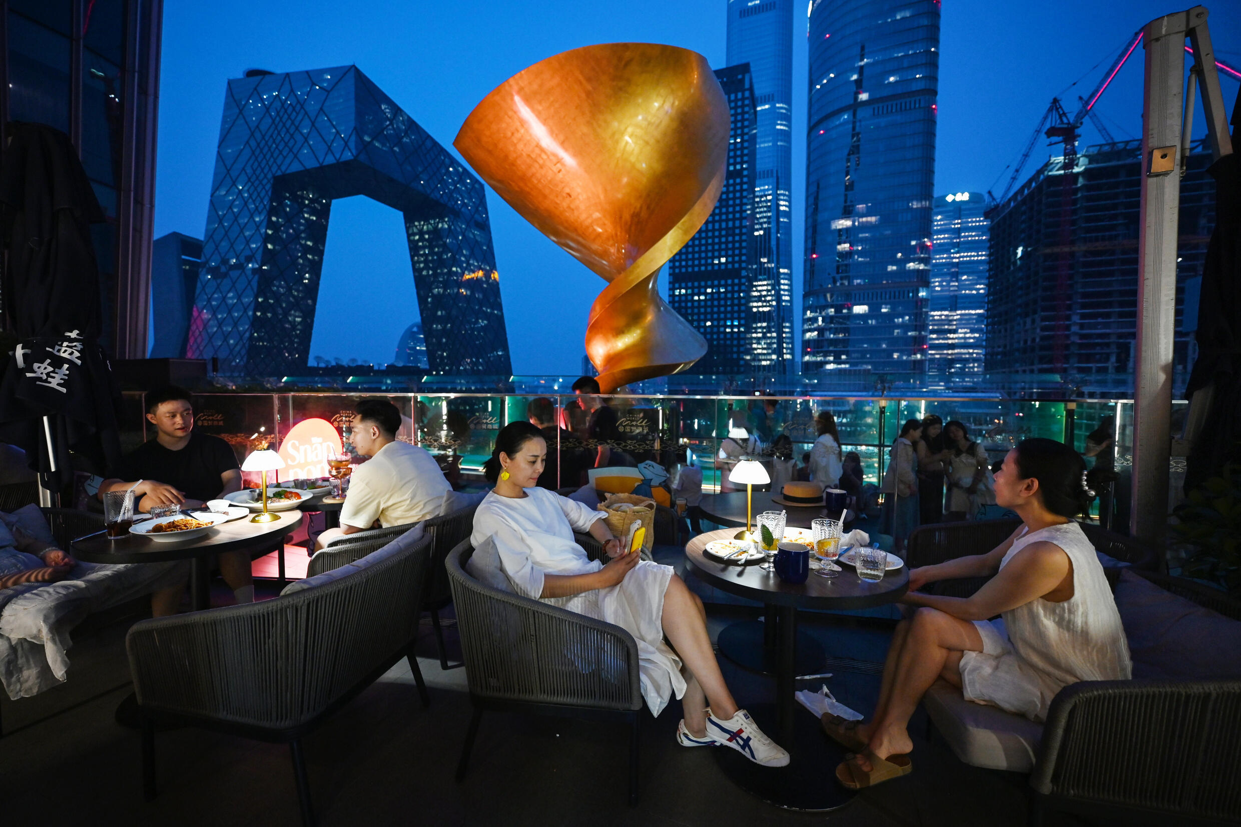 Des clients mangent dans un restaurant du quartier central des affaires de Pékin, le 11 juillet 2024