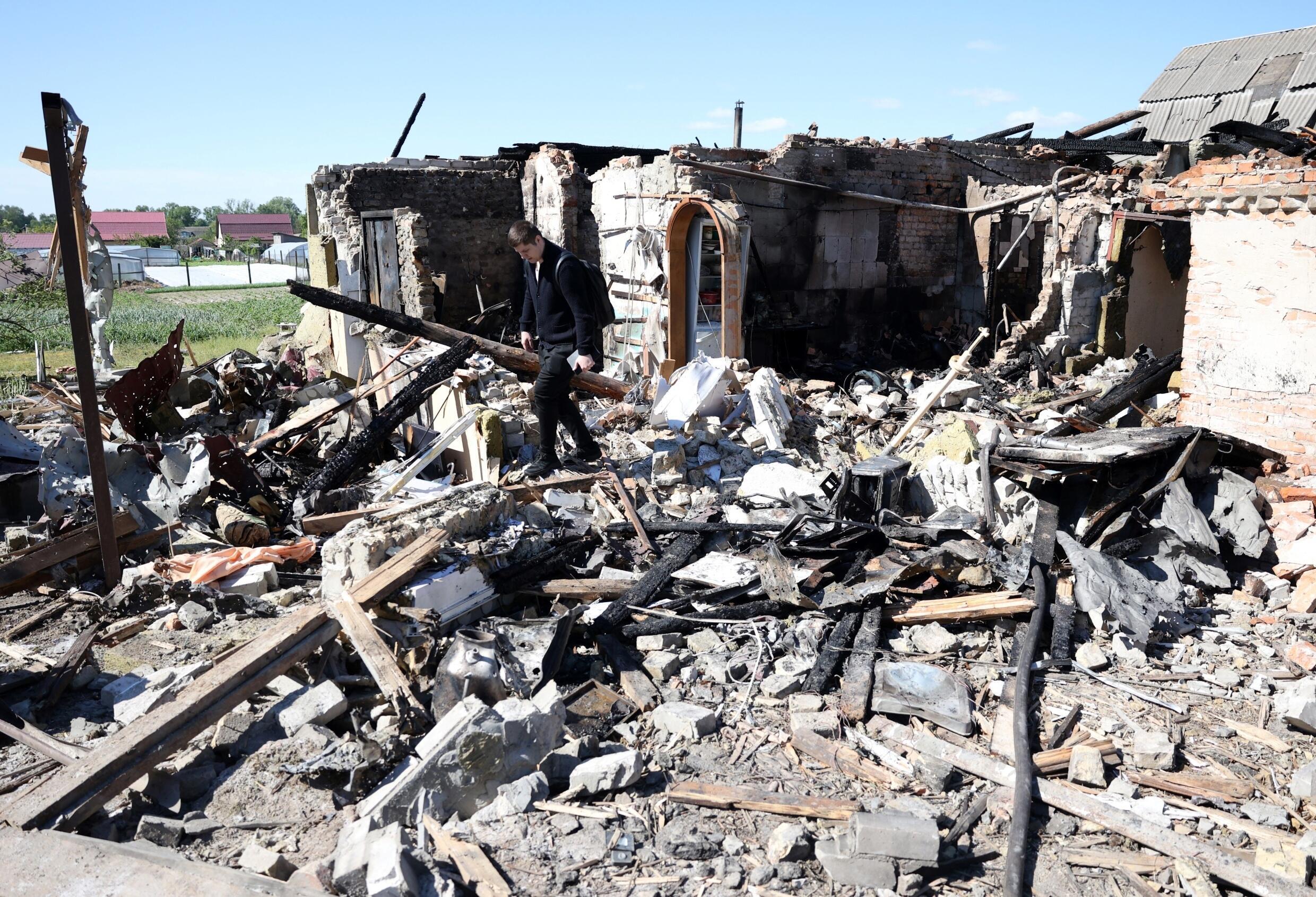 Un habitant dans les décombres d'une maison détruite par une attaque de missiles dans le village de Krasylivka, dans la région de Kiev, le 8 mai 2024 en Ukraine.