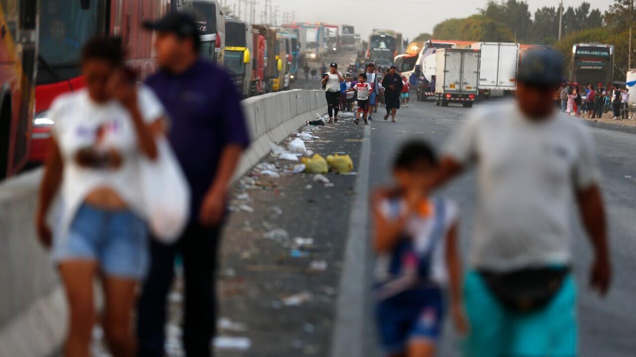 La gente camina a lo largo de la carretera Panamericana Norte, donde los partidarios del depuesto presidente peruano Pedro Castillo han bloqueado la carretera, en Chao, Perú, miércoles 14 de diciembre de 2022.