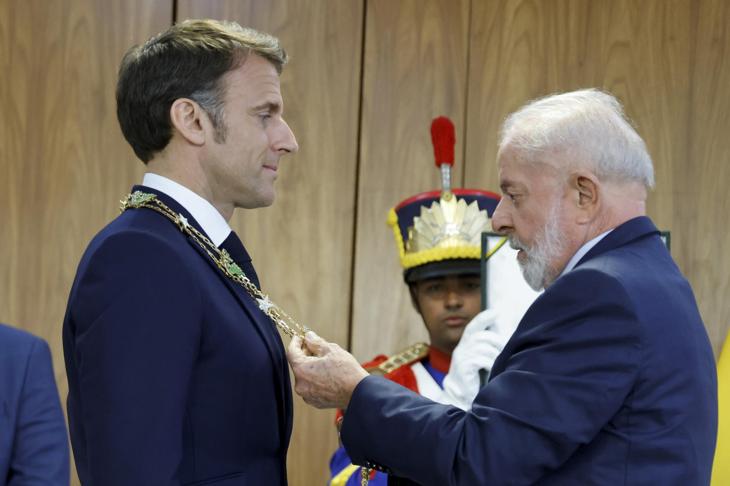 Le président brésilien Luiz Inacio Lula da Silva (d) décore son homologue français Emmanuel Macron de l'Ordre national de la Croix du Sud, honneur distinguant des étrangers de marque, le 28 mars 2024 à Brasilia