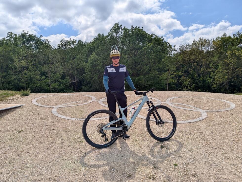 Joaquim Lombard posant devant les anneaux olympiques à la colline d'Élancourt.