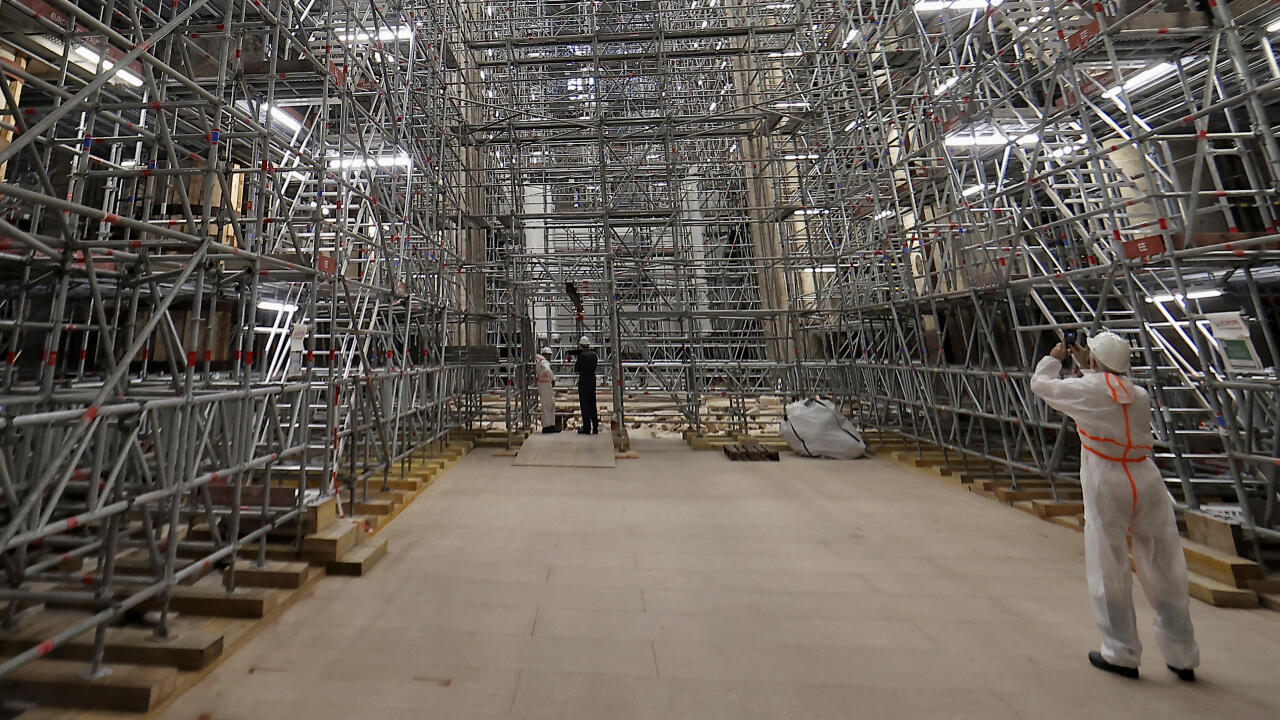 Un trabajador toma una foto de los andamios en el sitio de reconstrucción antes de una visita del presidente francés Emmanuel Macron en la Catedral de Notre-Dame de París, que fue dañada en un devastador incendio hace tres años, mientras los trabajos de restauración continúan, en París, Francia, 15 de abril de 2022.