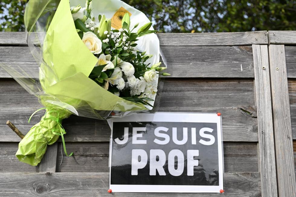 Des fleurs et une affiche "Je suis prof" près du collège du Bois d'Aulne à Conflans-Sainte-Honorine, dans les Yvelines, le 16 octobre 2023.