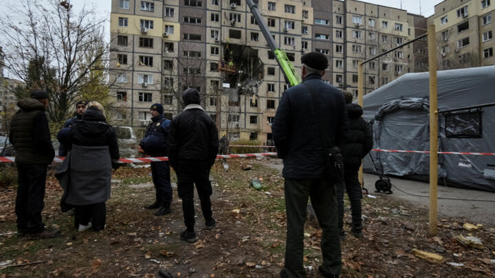 Residents stand near apartment buildings hit during a Russian drone strike in Dnipro, Ukraine on November 8, 2025.