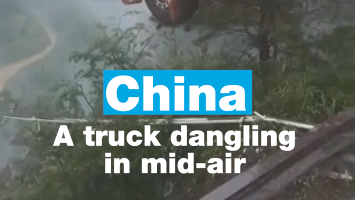China: Truck with driver inside dangling in mid-air