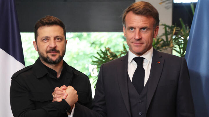 France's President Emmanuel Macron shakes hands with Ukraine's President Volodymyr Zelensky as they meet on the sidelines of the two-day NATO's Heads of State and Government summit in The Hague.